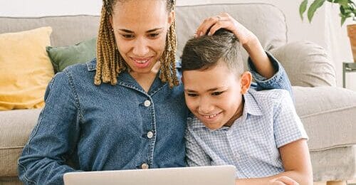 woman and child reading on a computer